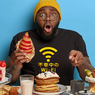stupefied-black-man-eats-tasty-croissant-points-at-table-full-of-sweet-delicious-desserts-wears-hat-and-t-shirt-poses-against-blue-background.jpg