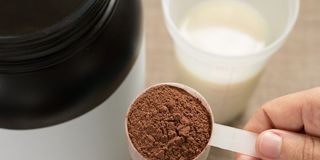 close-up-of-hand-holding-whey-cup-on-table-royalty-free-image-1618889930_.jpg