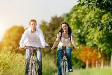 26107741-happy-young-couple-cycling-with-bicycle-in-summer-in-nature-man-and-woman.jpg