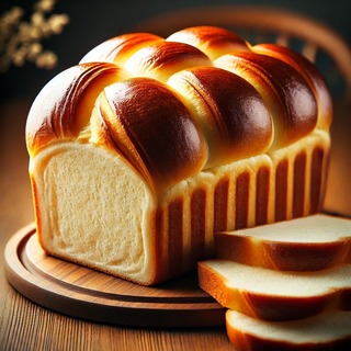 DALLEE 2024-09-21 23.03.52 - A freshly baked Brioche loaf with a soft, golden-brown crust and a rich, buttery interior. The loaf is slightly puffed and glossy on top, showing its .jpg